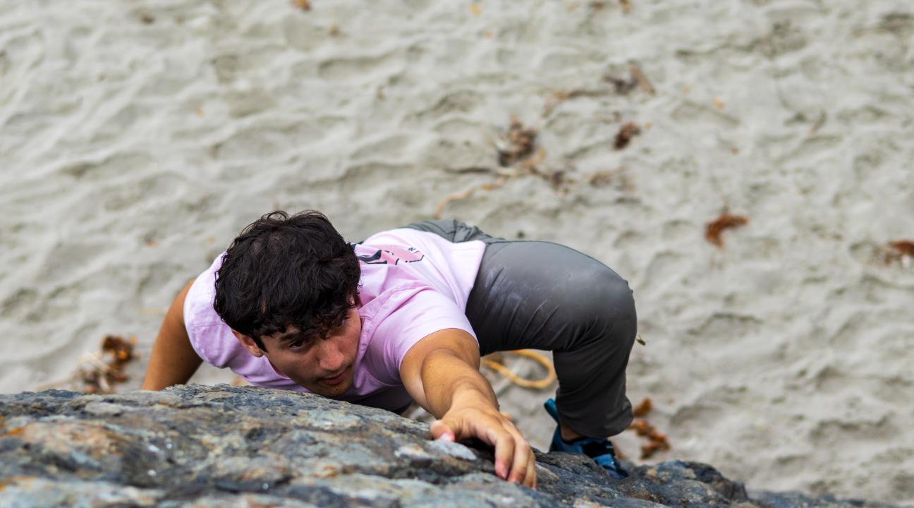 student climbing outdoor boulder