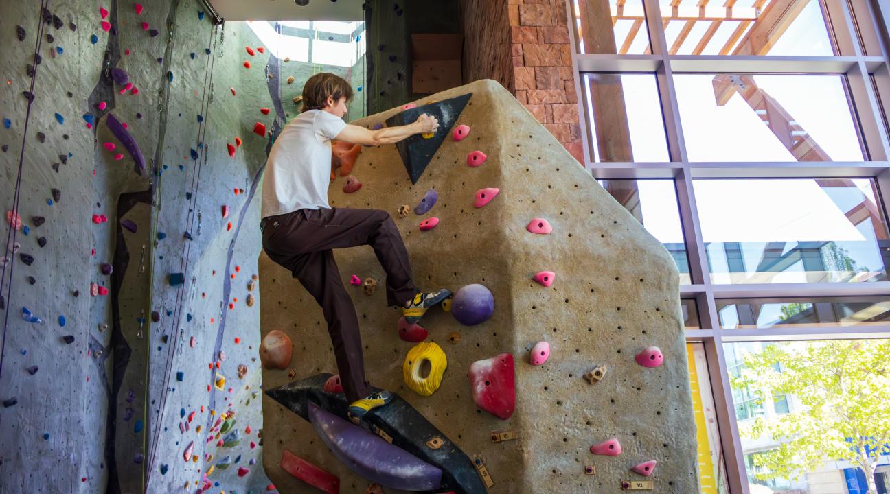 student climbing indoor rock wall
