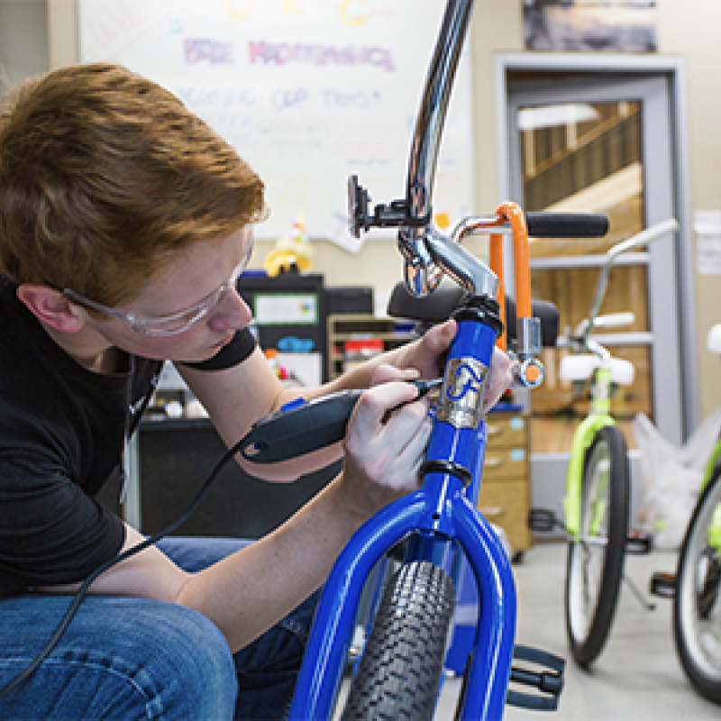 student working on bicycles
