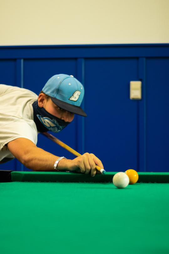 Student playing billiards