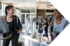 two students on treadmills smiling