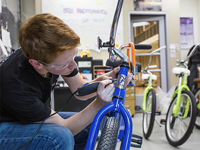 student working on bicycles