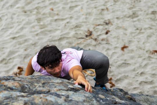 student climbing outdoor boulder