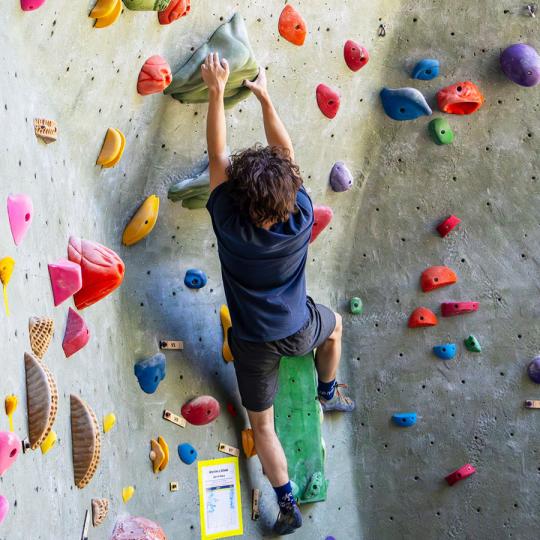 student climbing the climbing wall