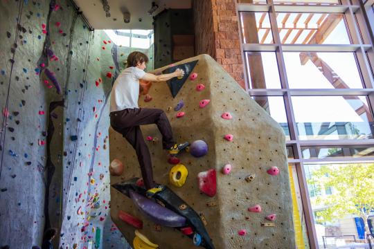 student climbing indoor rock wall