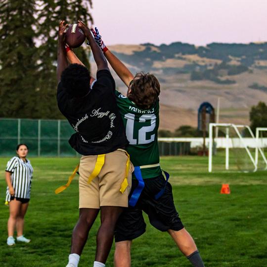 two students playing flag football