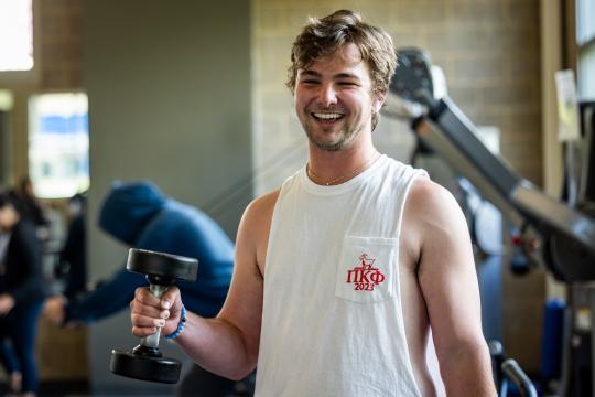 Student lifting weights at rec center