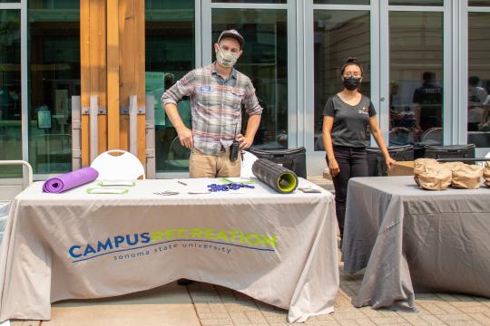 picture of Reed Mathieson standing by Campus Rec table at Rec Fest 2021