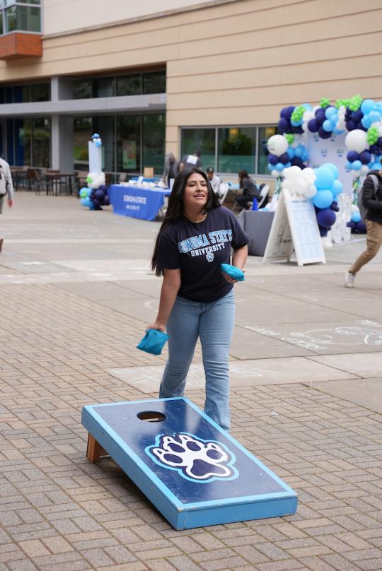 student playing cornhole