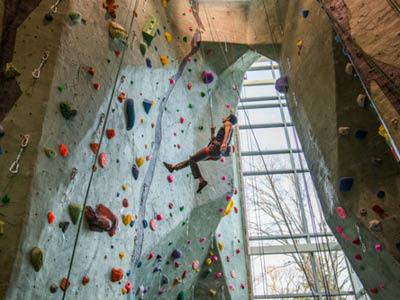 student on rock wall at rec center