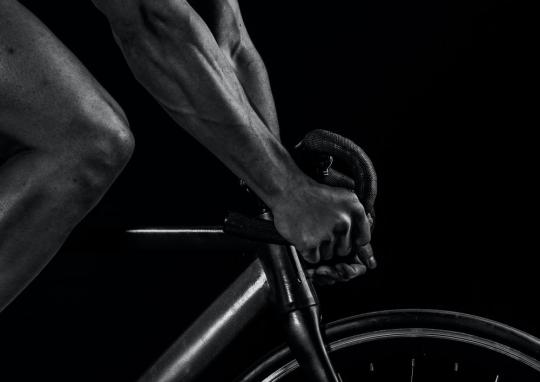 black and white closeup of a person on a bike