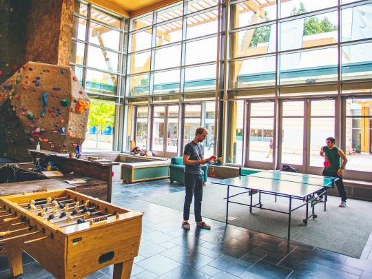 a room with rock wall and ping pong tables