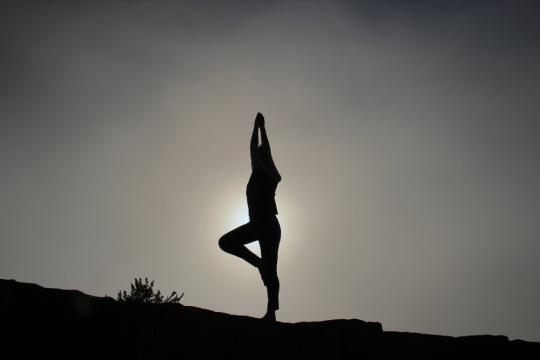 person practicing yoga in greyscale