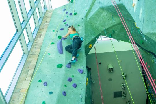 student climbing on rock wall