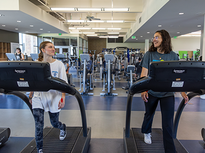 Two students walking on treadmils
