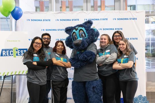 students and staff posing with mascot