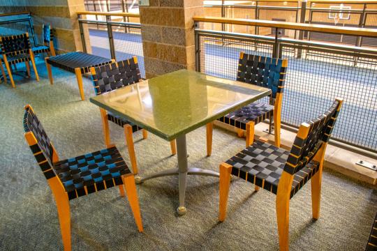 Table with four chairs in a modern indoor seating area.