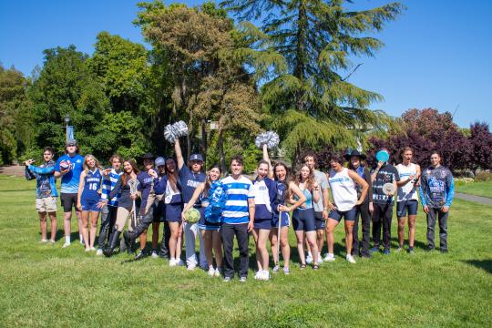 Various Sonoma State University athletes in an assortment of sports uniform posing in V formation. 
